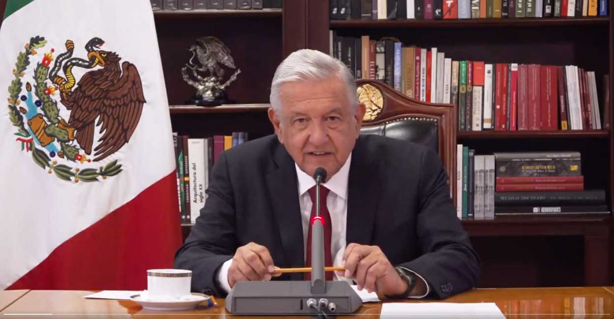Andrés López Obrador sentado en su escritorio.