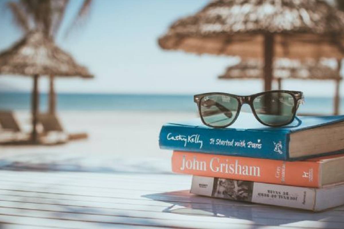 Libros en la playa y lentes de sol